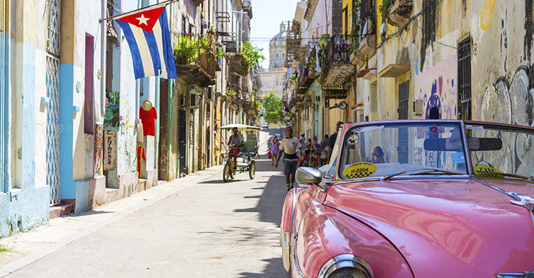 Vue sur une rue de Cuba avec ancienne voiture en premier plan (Unsplash-AlexanderKunze)