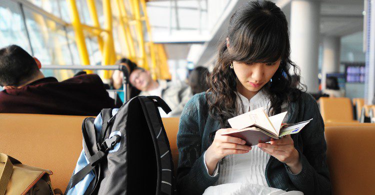 Jeune femme dans un aéroport en train de lire (Istock)