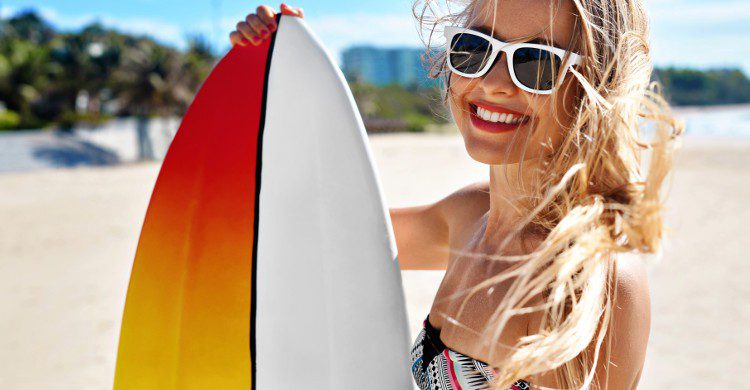 Jeune femme blonde avec une planche de surf 