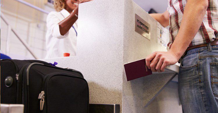 Jeune femme en train de présenter son passeport avant d'embarquer (Istock)