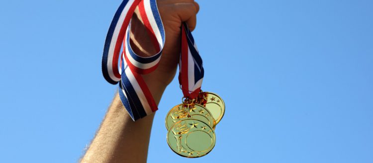 Médailles olympiques tenues dans une main levée