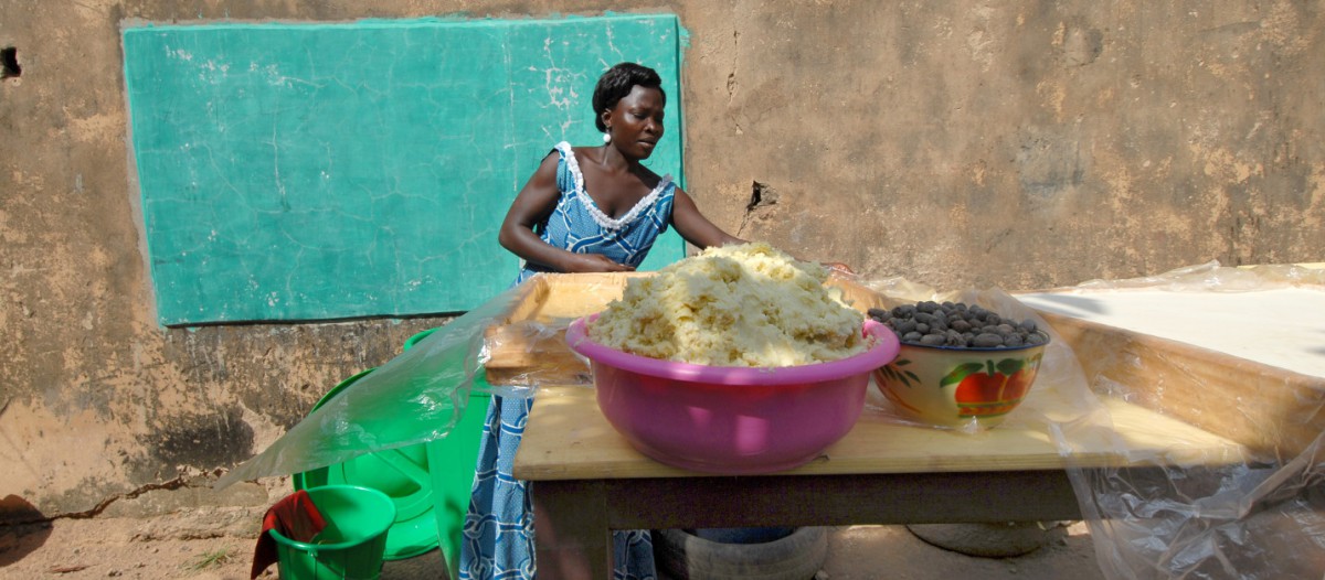 Femme vendant du beurre de karité artisanal en Afrique