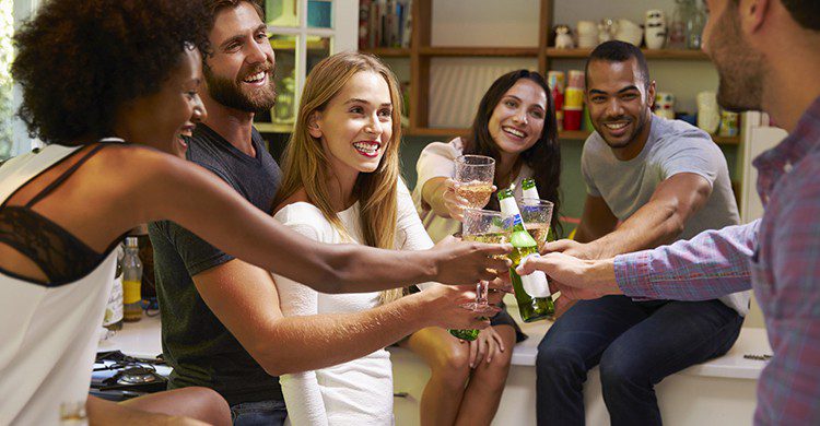 Groupe d'amis en train de trinquer dans un salon (Istock)