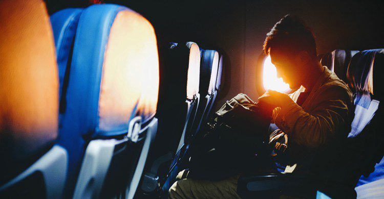 homme assis à son siège dans la cabine d'un avion